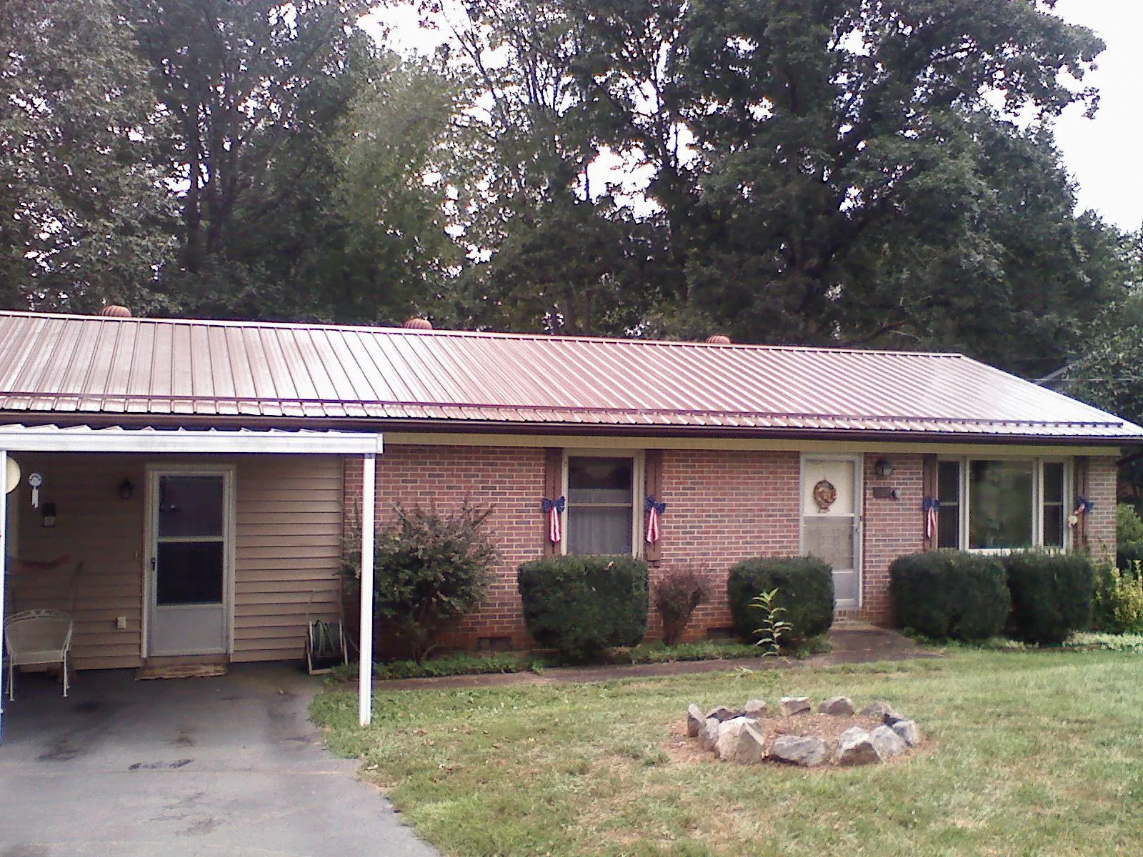 Bronze metal roof and carport on a brick ranch home — Roof Repair work by our crew in Millport